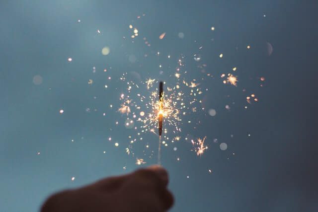A person holding a single and lit sparkler to illustrate New Years Eve celebrations. A person holding a single and lit sparkler to illustrate New Years Eve celebrations.