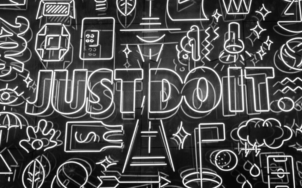 A black background and white neon text and graphics. The text in neon also reads "Just do it" to symbolise Nike's famous tagline.
