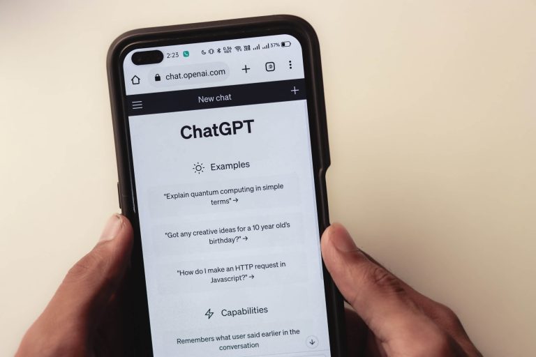 A person holding a phone with the screen open to Chat GPT and some prompts.