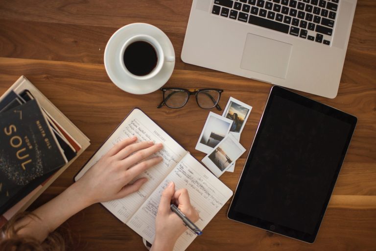 A bird's eye view of a person writing in a notebook.
