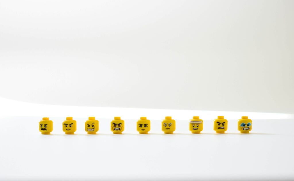 A group of Lego heads in a line, each denoting a different facial expression as a nod to AI developing its emotional intelligence.