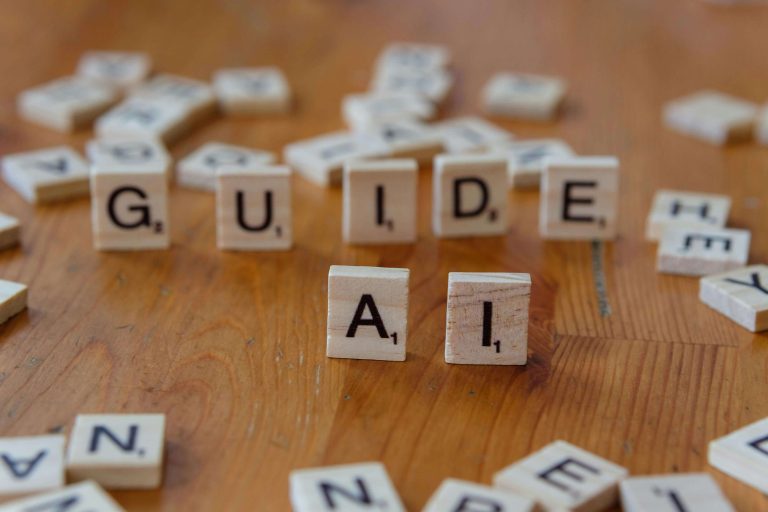 Scrabble tiles on a table, spelling out "AI Guide".