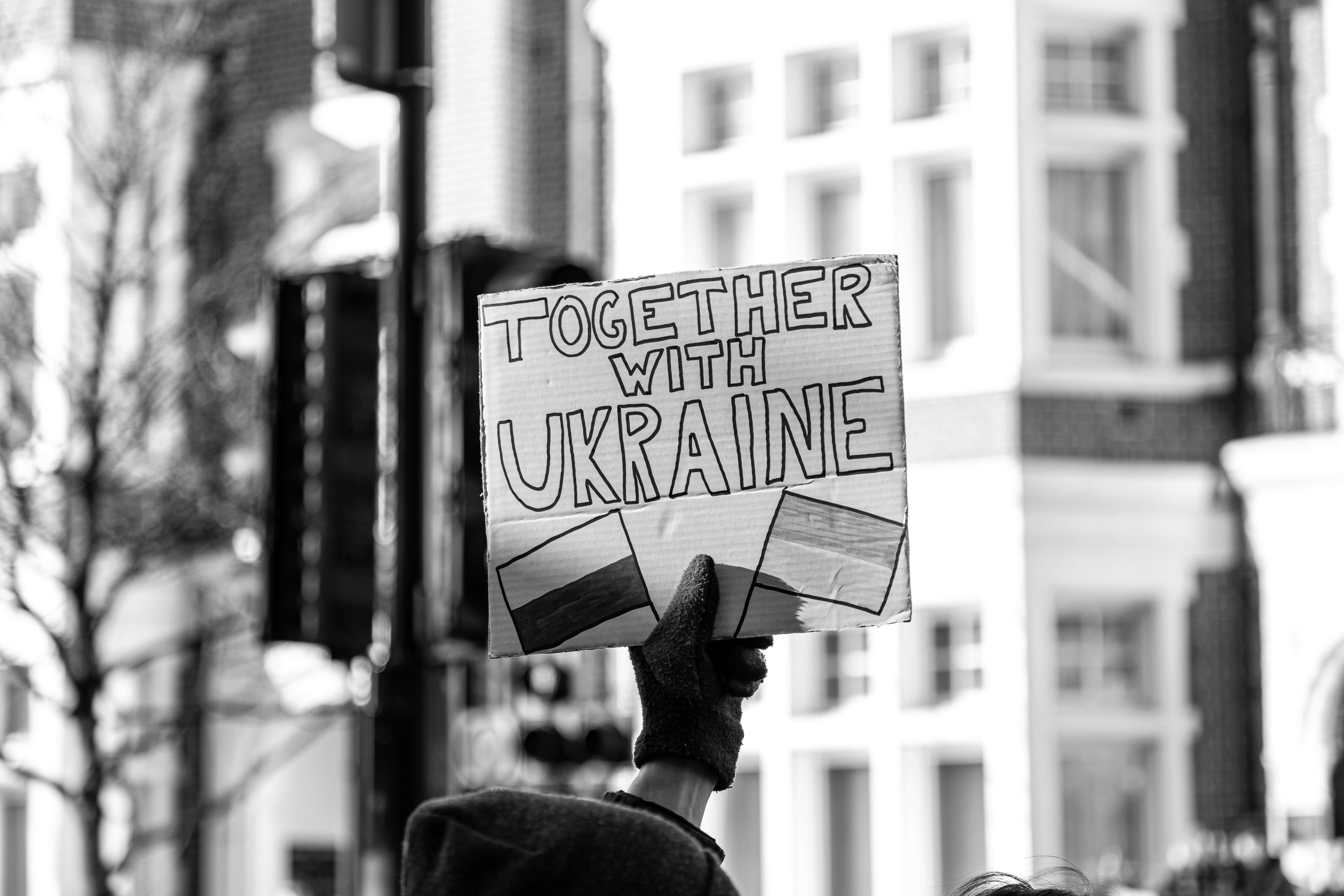 A protester holding up a sign saying "Together With Ukraine".
