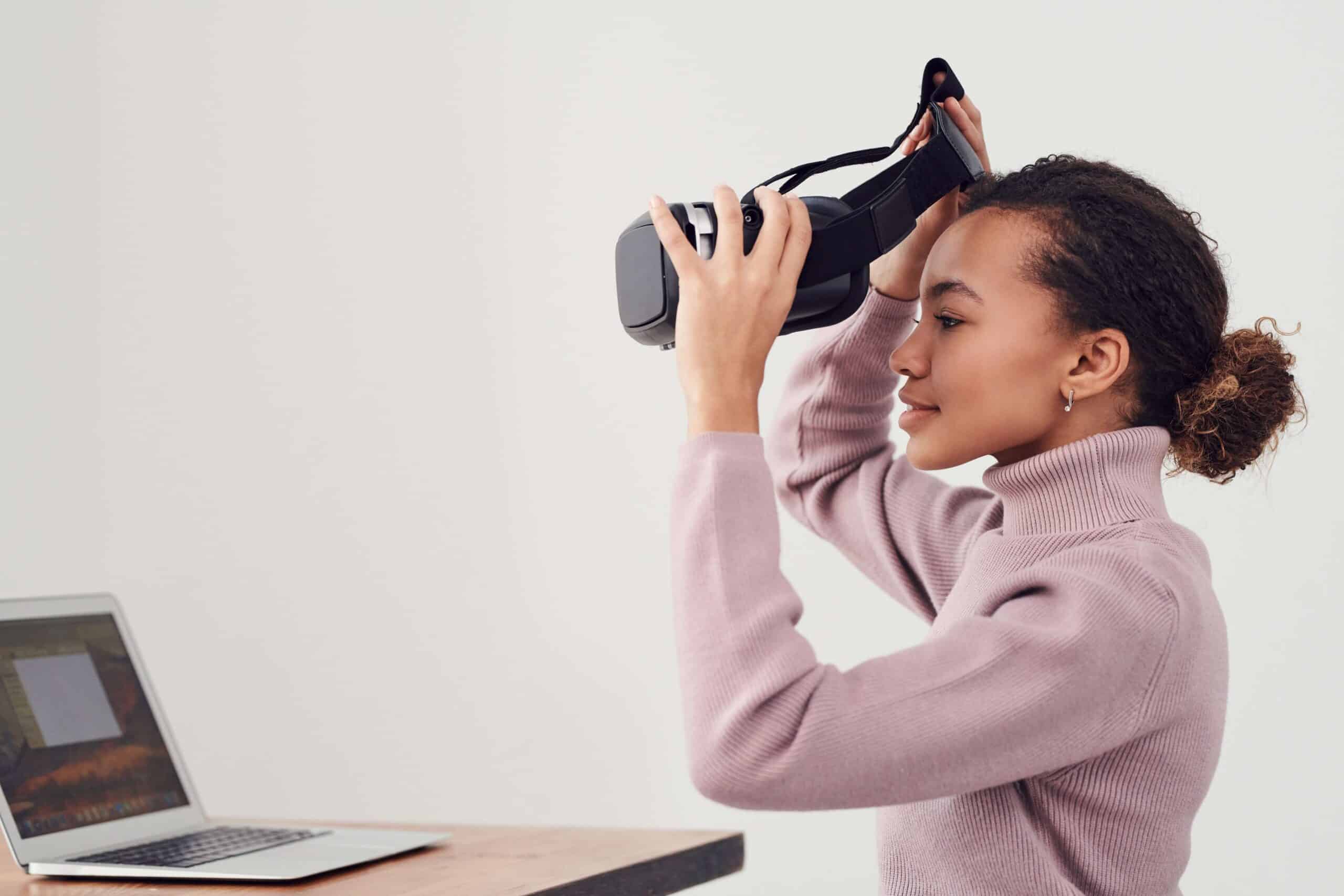 A woman sitting down and trying on a virtual reality/metaverse headset.